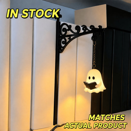 Black metal shelf ornament with glowing ghost silhouette hanging from chain