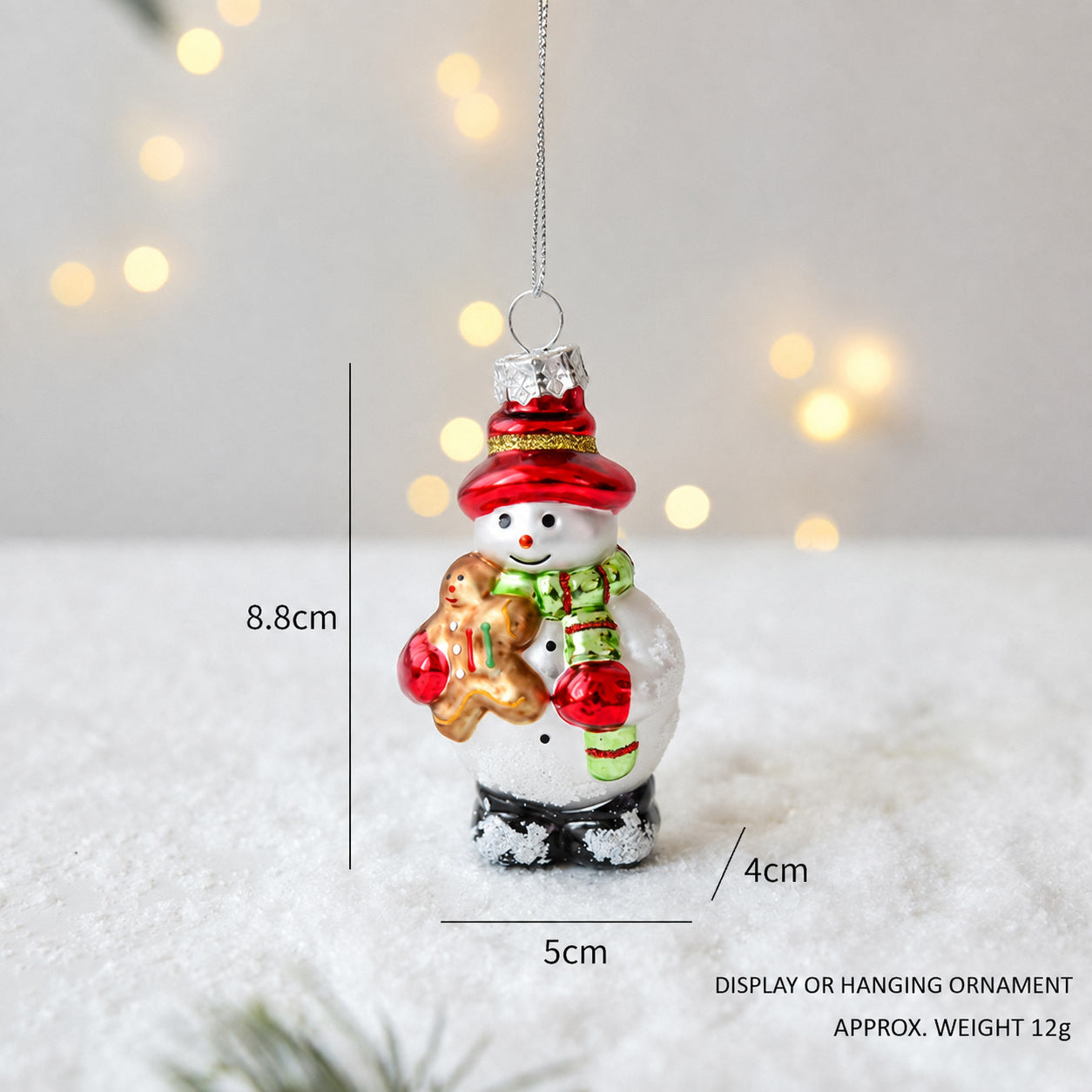 Handmade glass Christmas snowman hanging ornament in red hat and scarf holding a gift