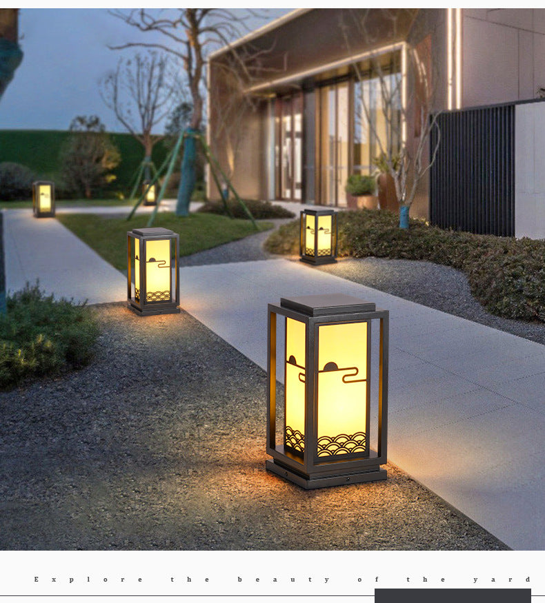 Black solar lantern light with warm glow along garden pathway, rectangular glass panels