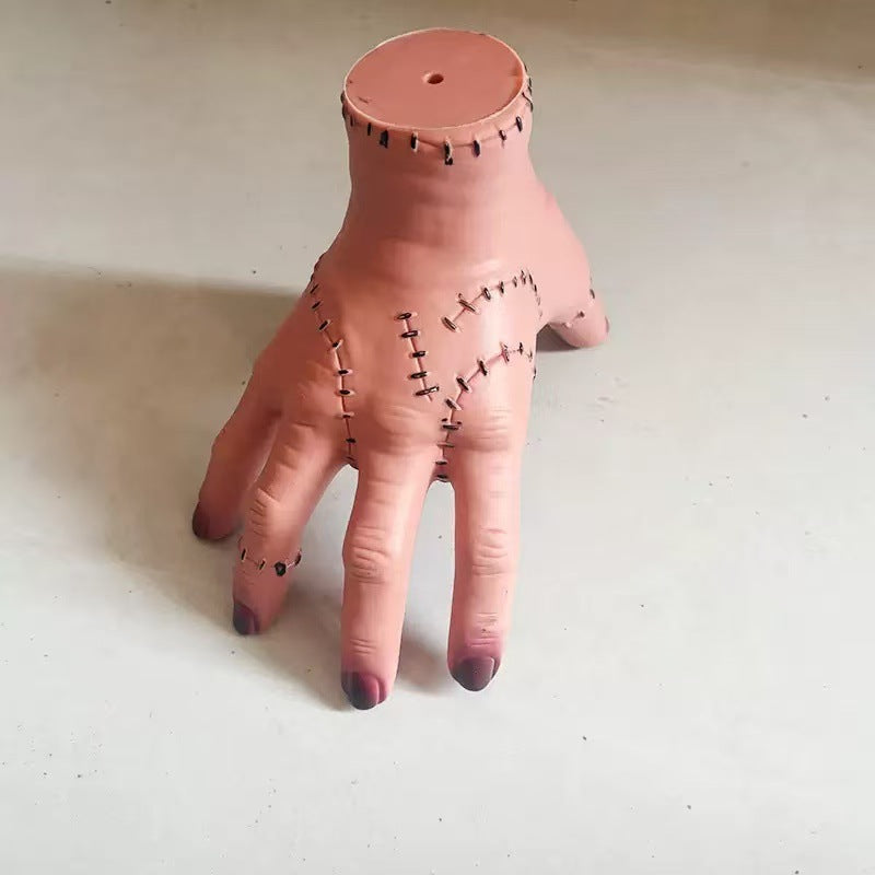 Halloween severed hand prop, pinkish flesh tone with stitched seams and cut wrist.