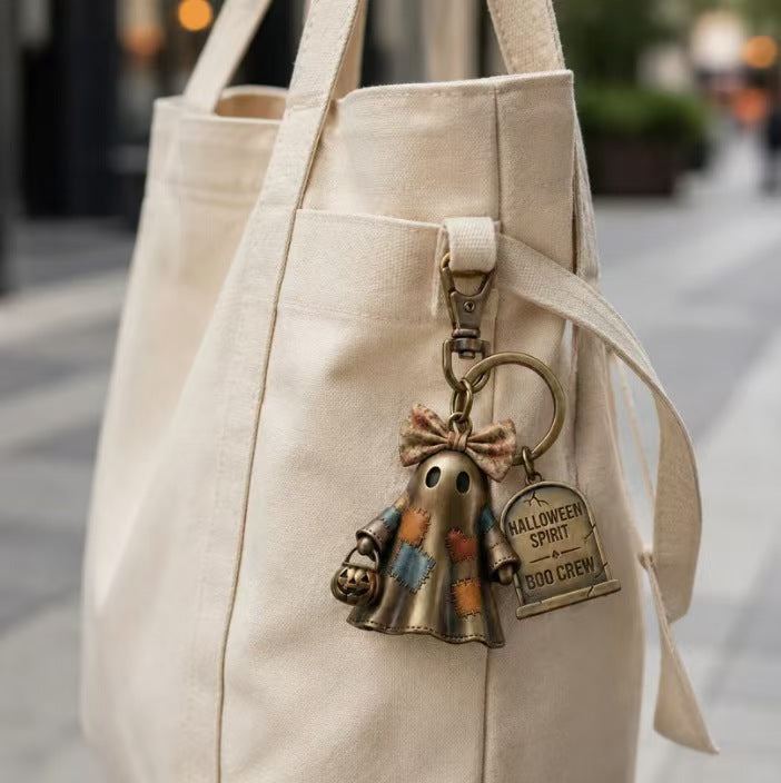 Ghost keychain charm on beige tote bag, bronze ring with Boo Crew tag