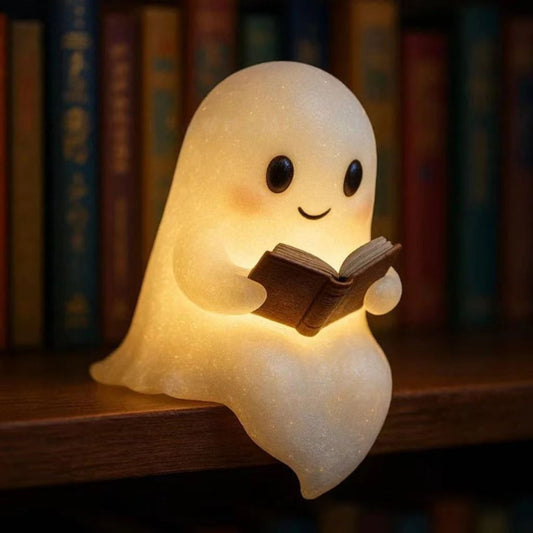 Glowing ghost reading book lamp with smiling face and warm light