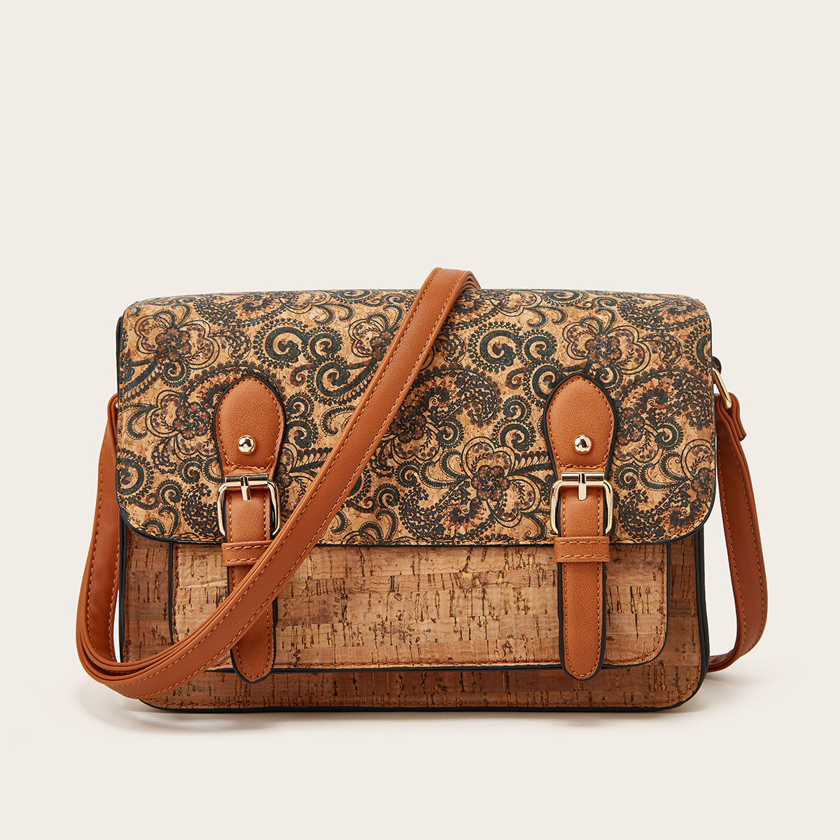 Women’s crossbody bag with tan scroll pattern flap and brown leather shoulder strap