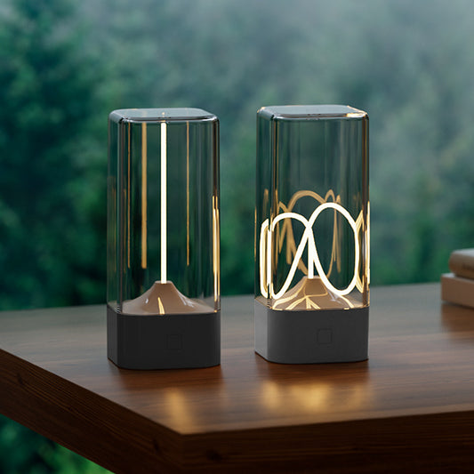 Portable LED night light with clear glass cylinder and dark base, warm glowing vertical filament