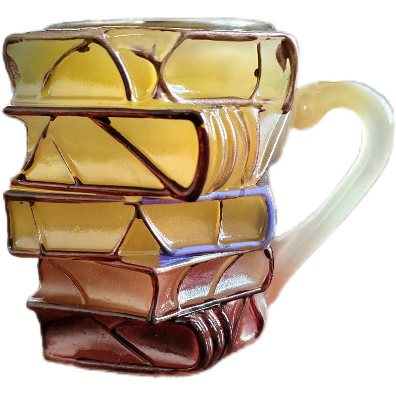 Close-up resin mug with stacked book texture and pale handle, glossy finish.