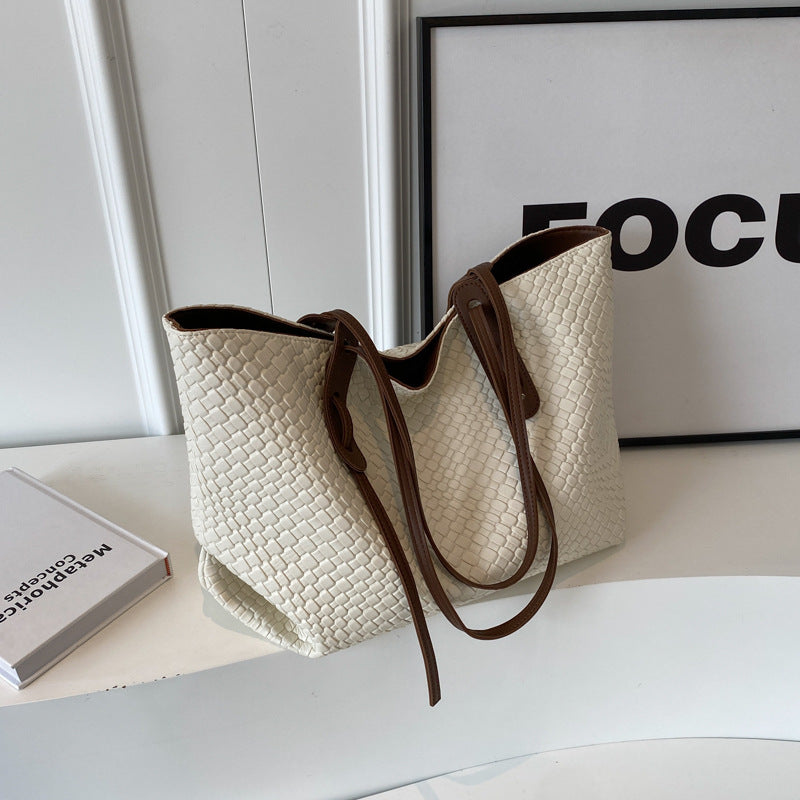 Woven PU tote bag in off-white/cream with brown trim and long shoulder strap