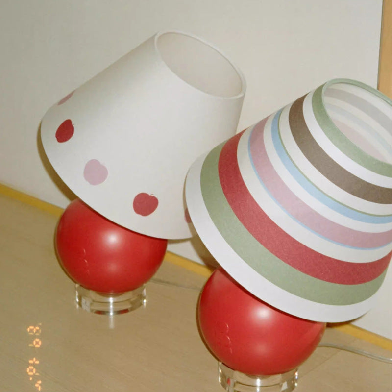 Apple-shaped lamp with red base and white shade featuring red heart dots; multi-color rim.