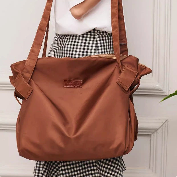 Dark brown large-capacity travel duffel bag with side pockets and shoulder straps