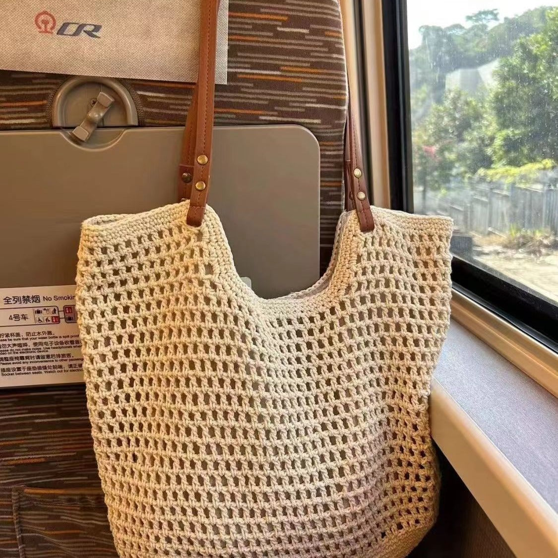 Off-white woven mesh tote bag with open top and brown leather shoulder straps