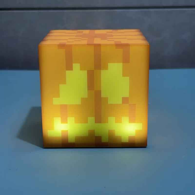 Yellow Minecraft-style cube night light with green pixel pattern and warm glow