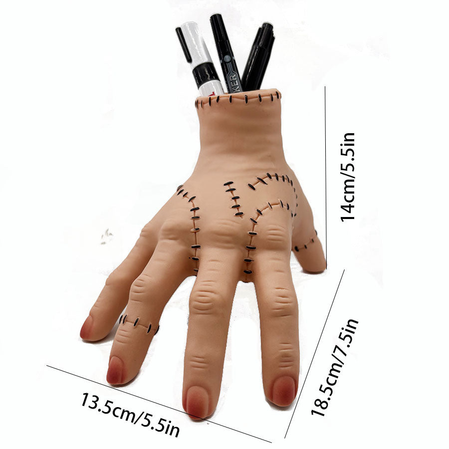 Halloween severed hand prop holding black markers, stitched palm and wrist opening.