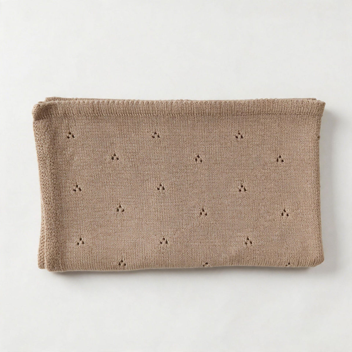 Oatmeal cotton baby blanket with small hollow floral embroidery, neatly folded