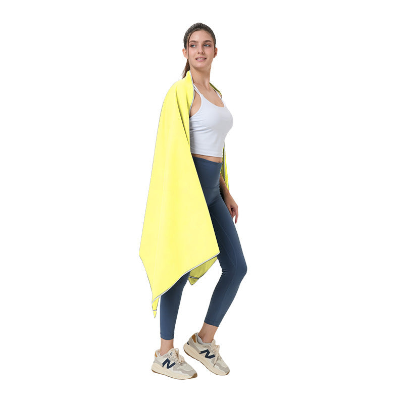 Quick-dry microfibre beach towel, yellow, draped over a person