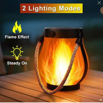 Solar flame-effect lantern with black body, orange flickering LED glow, hemp rope handle