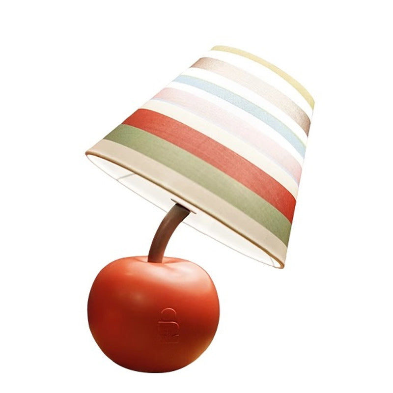 Apple-shaped lamp with red base and multi-color striped lampshade on white background.