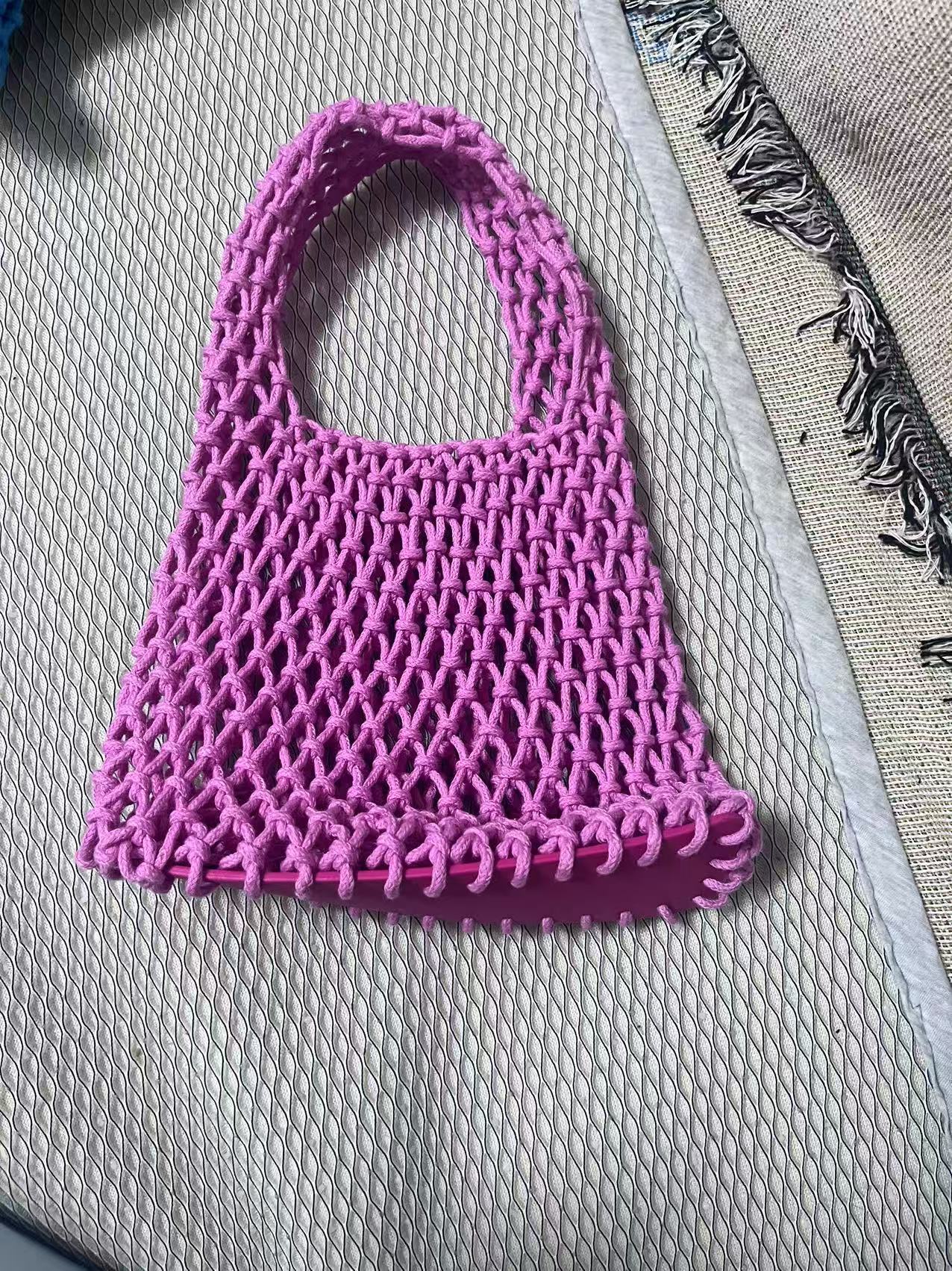 Pink woven cotton rope bucket bag with hollow net texture and loop handle.