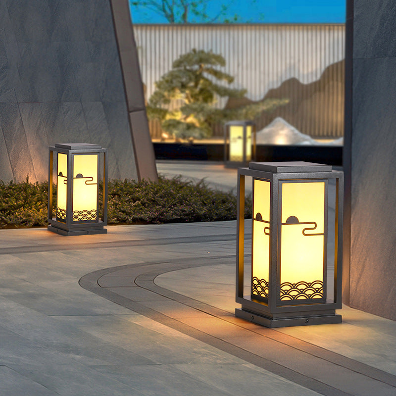 Set of solar lantern lights with black frames on patio walkway, warm light