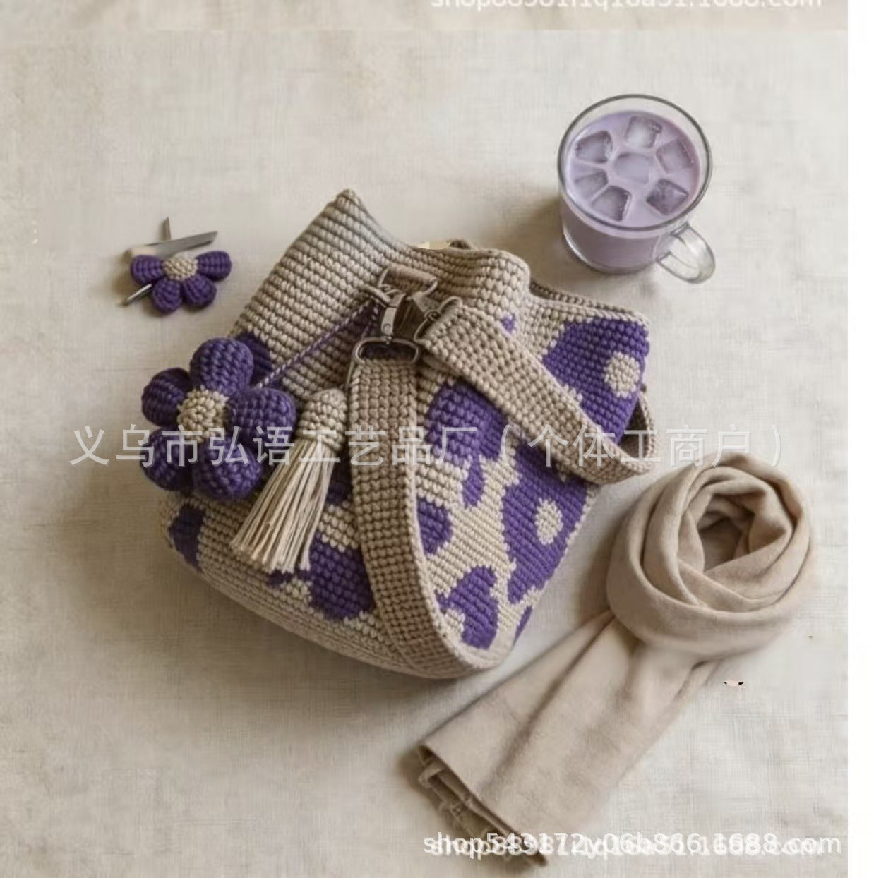 Beige crochet tote bag with purple flower appliques and hanging tassel fringe