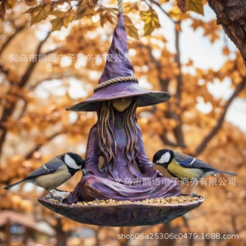 Purple witch-hat hanging bird feeder with seated witch and songbirds around the bowl