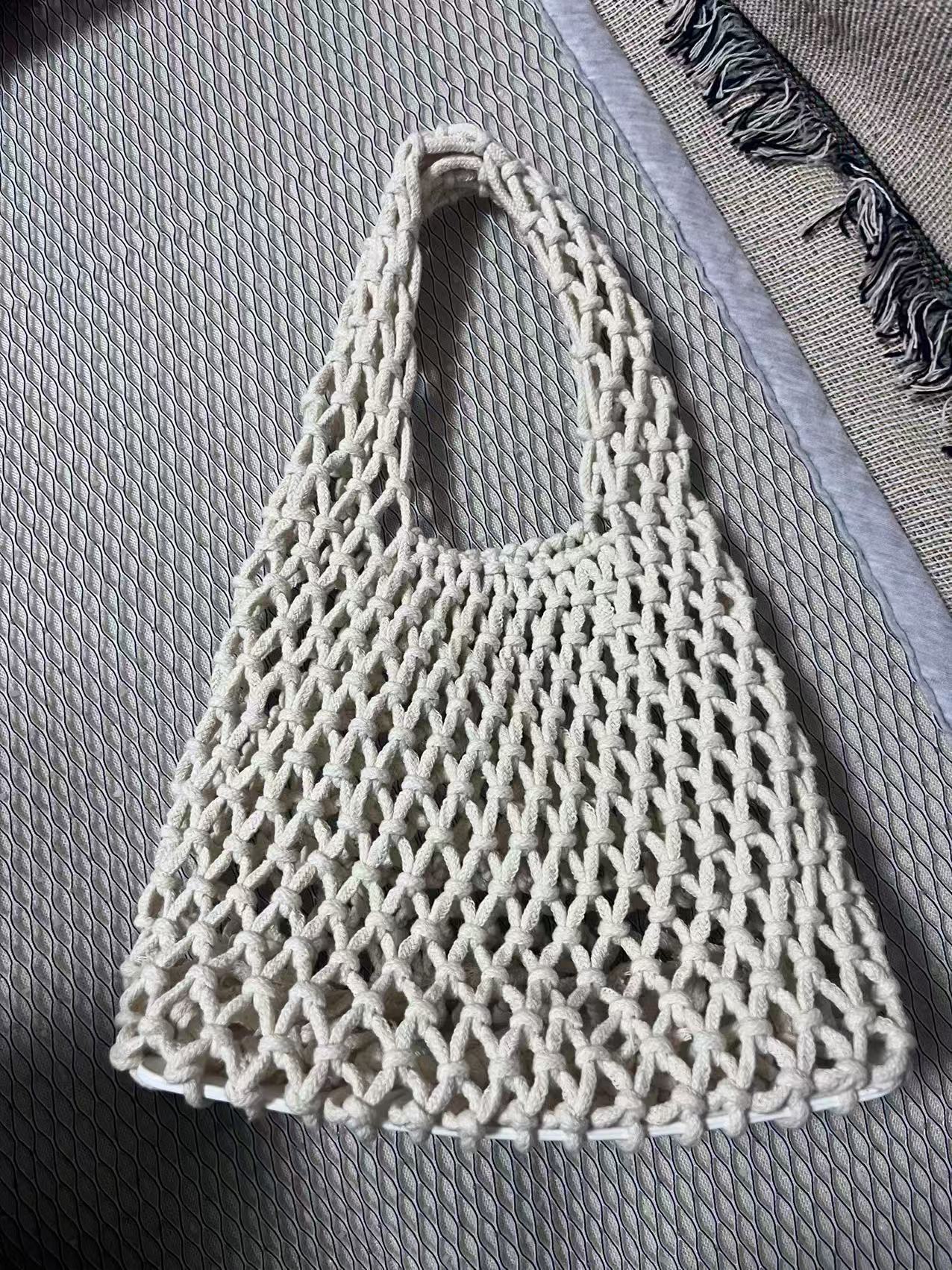 White woven cotton rope bucket bag with hollow net weave and loop handle.