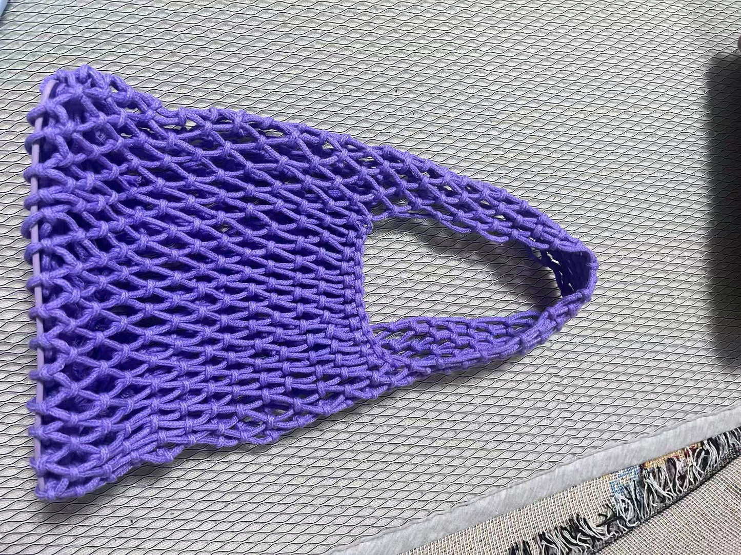 Purple crochet bucket bag with hollow net weave and rounded rope handle