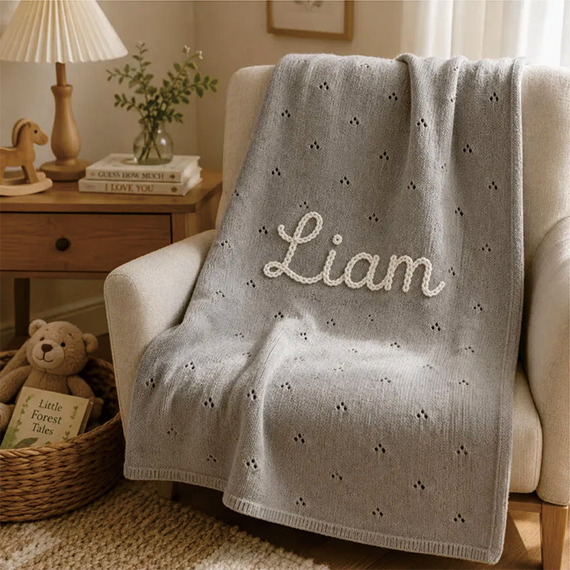 Gray cotton baby blanket with small hollow floral embroidery and custom name "Liam"