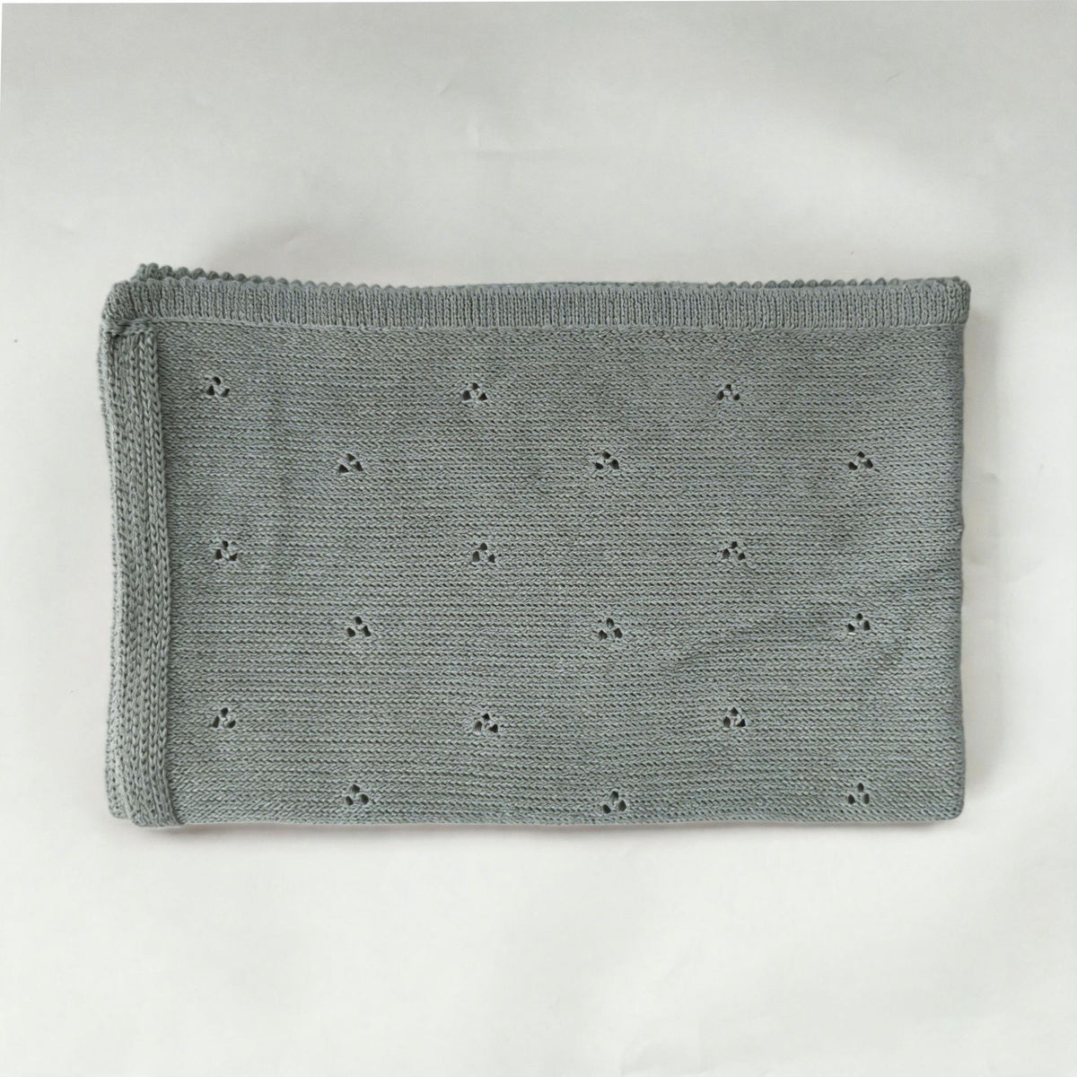 Gray cotton baby blanket with small hollow floral embroidery, neatly folded