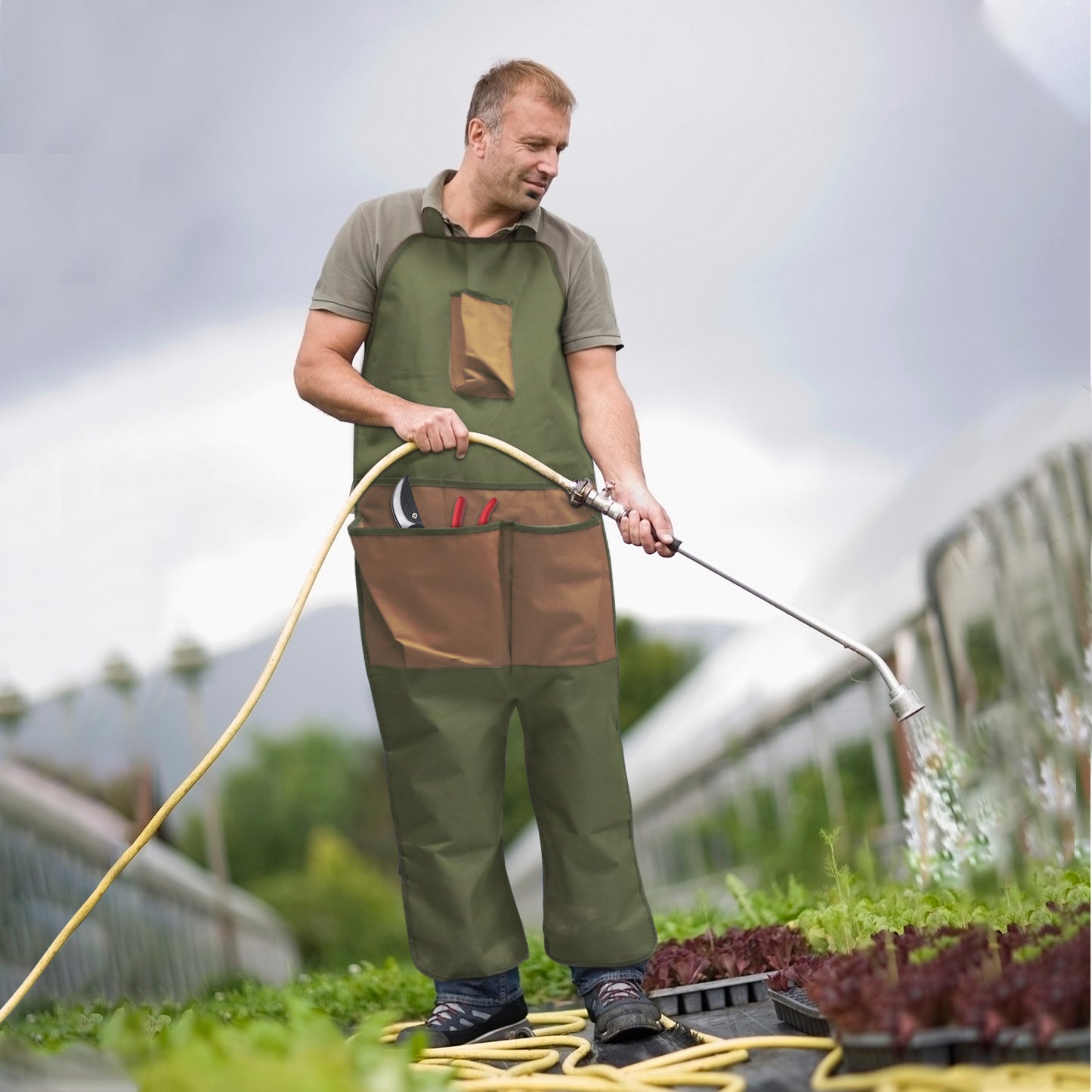 Green gardening leg apron with brown chest pocket and leg panels, adjustable shoulder straps