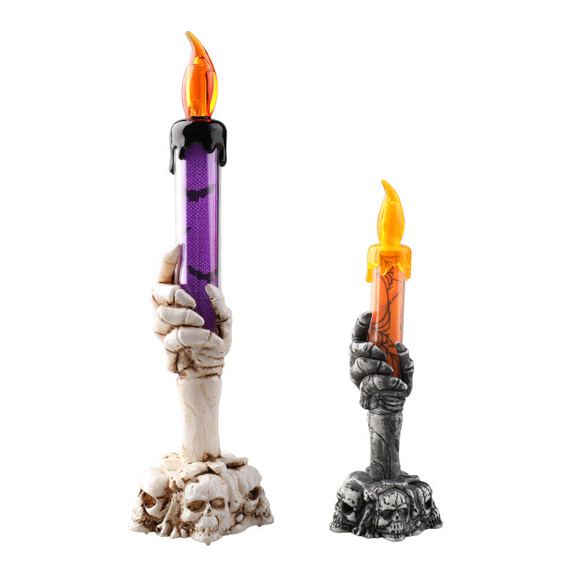 Pair of LED ghost hand candles with skull bases, purple and orange flickering flames