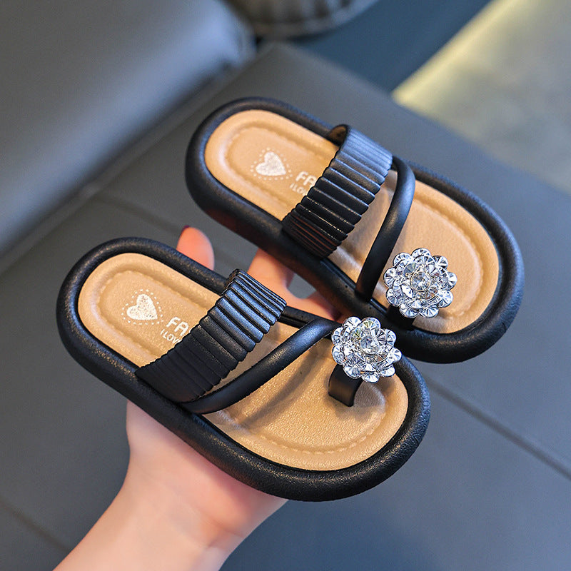 Black girls' flip-flops featuring rhinestone flower detail and padded footbed
