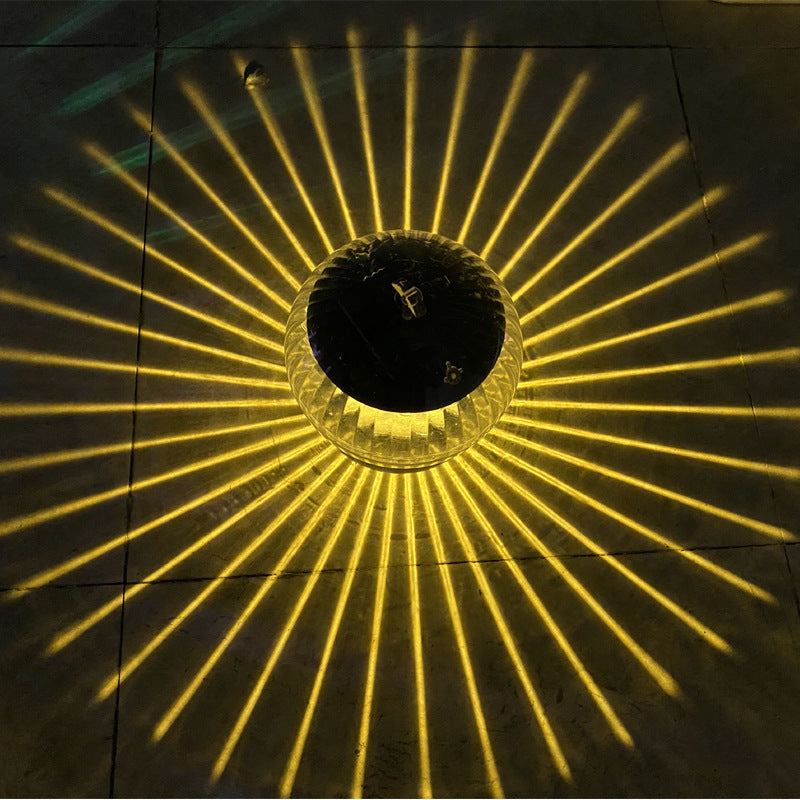 Single solar floating LED garden lamp with golden radial light burst and clear dome