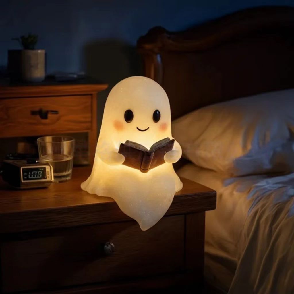 Ghost night light ornament showing ghost holding an open book, warm glow