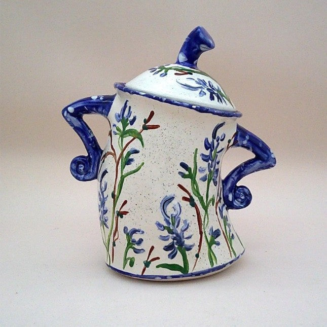 Decorative resin lidded jar, cream with blue botanical motif and curled navy side details