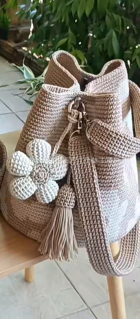 Beige crochet tote bag with white flower pom and tan tassel, single shoulder strap