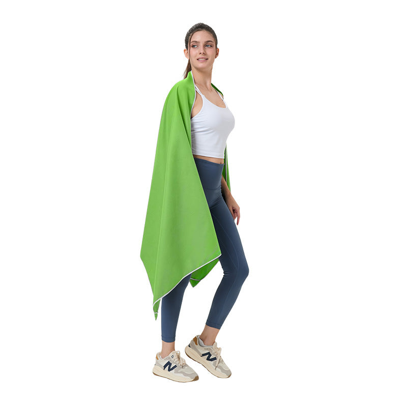 Quick-dry microfibre beach towel, bright green, draped over a person