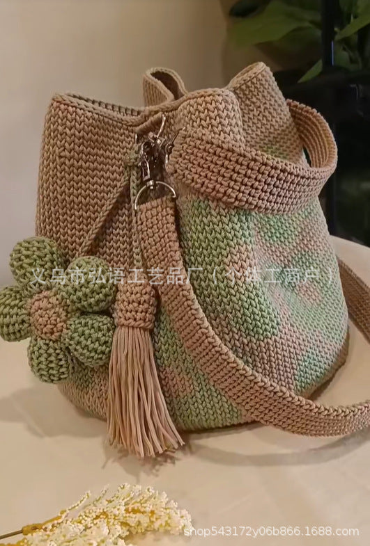 Crochet tote bag with green flower detail, beige body, and long tassel strap
