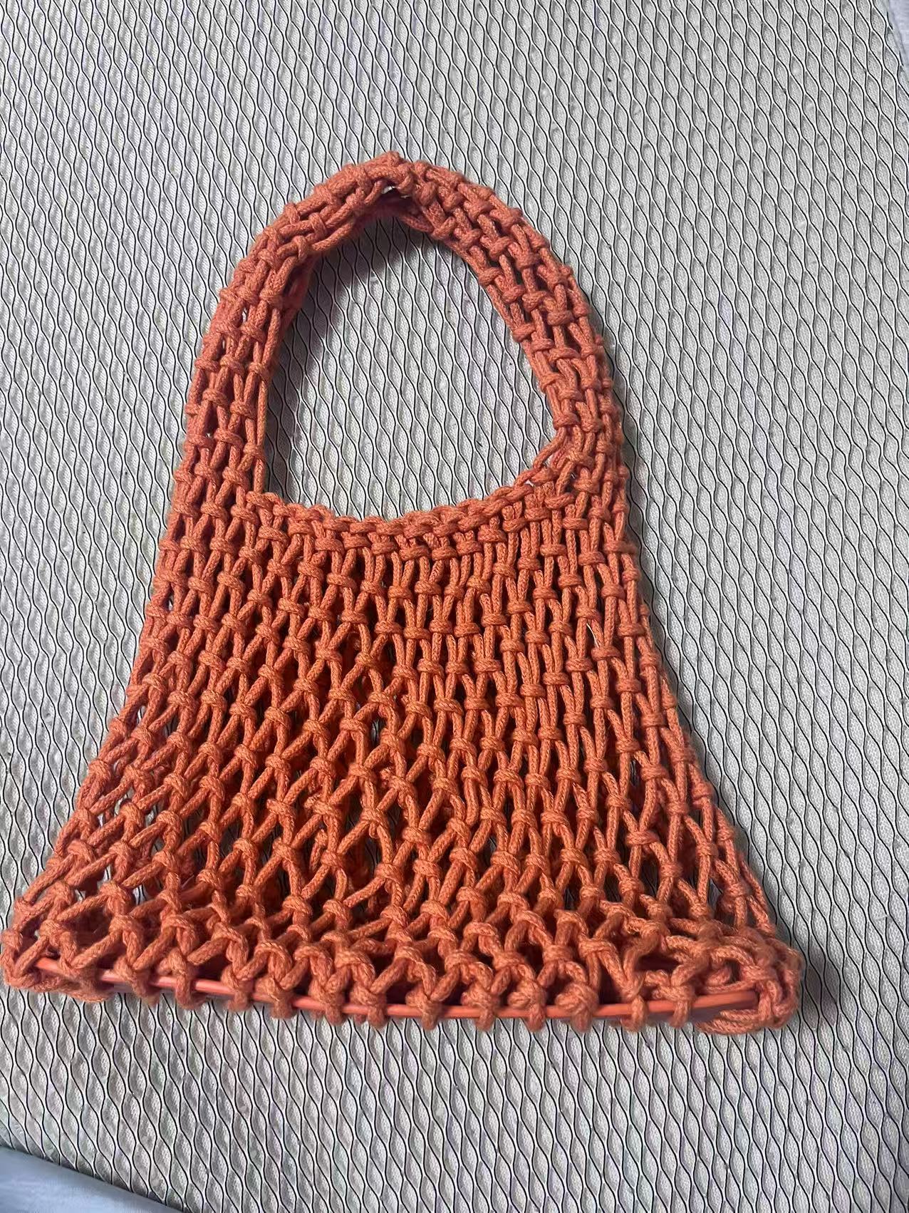 Coral orange woven cotton rope bucket bag with hollow net texture and rounded top handle