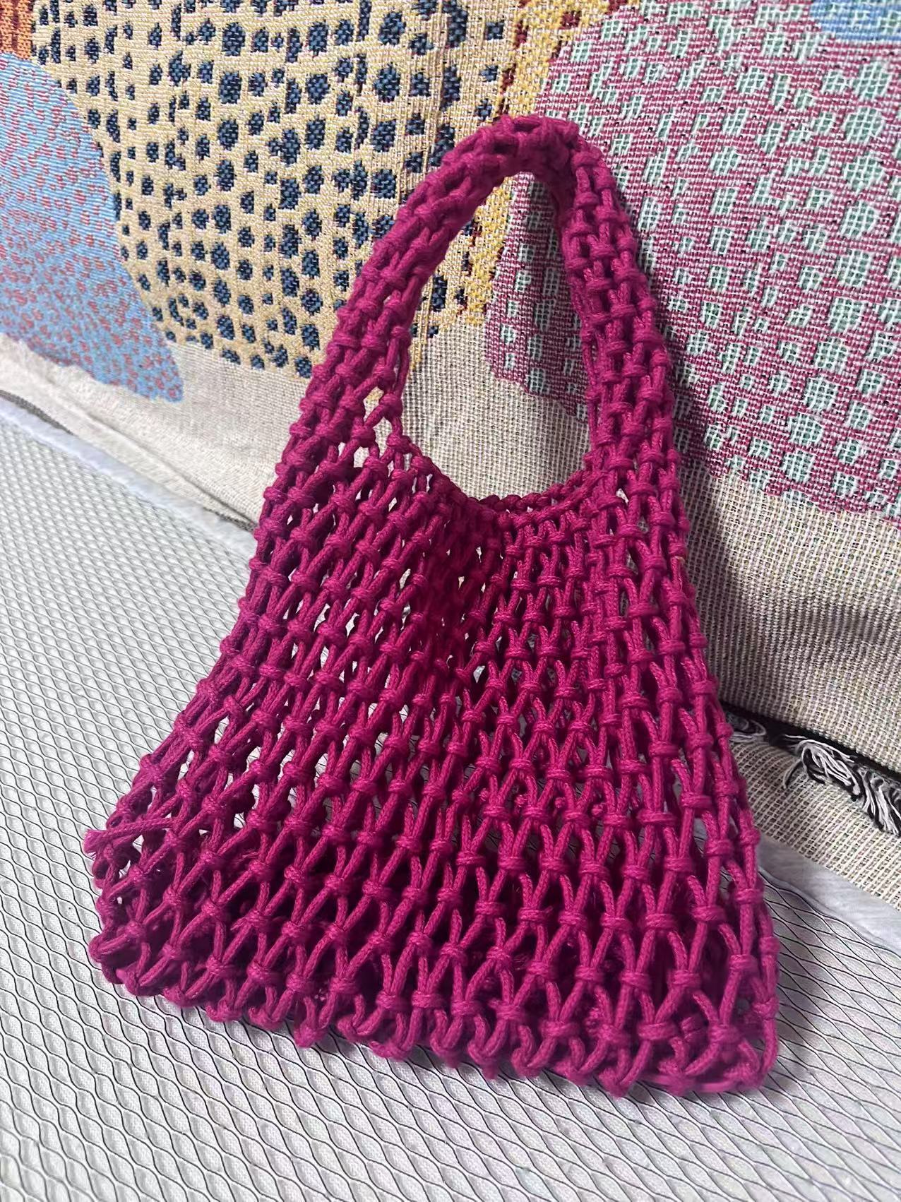 Magenta crochet bucket bag with hollow net texture and curved rope handle