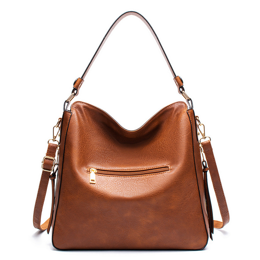 Brown PU leather shoulder bag with front zip pocket and braided tassel detail