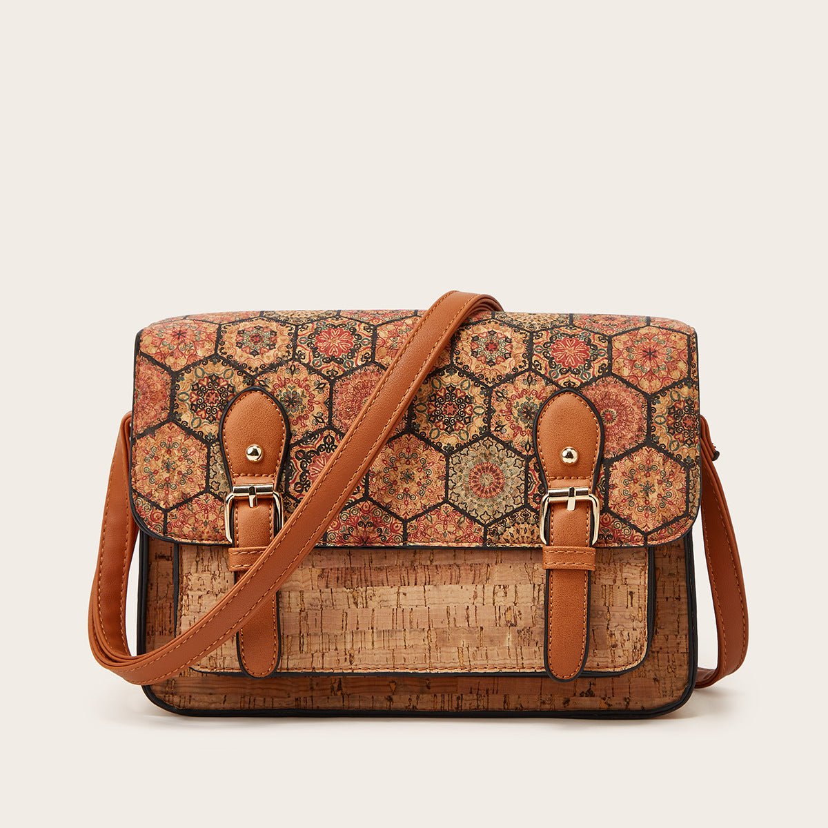 Women’s crossbody bag with red and orange patterned flap and brown leather shoulder strap