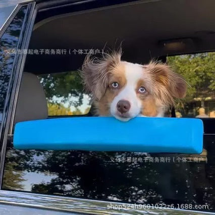 Dog car window chin rest, bright blue bar across the window with dog looking out
