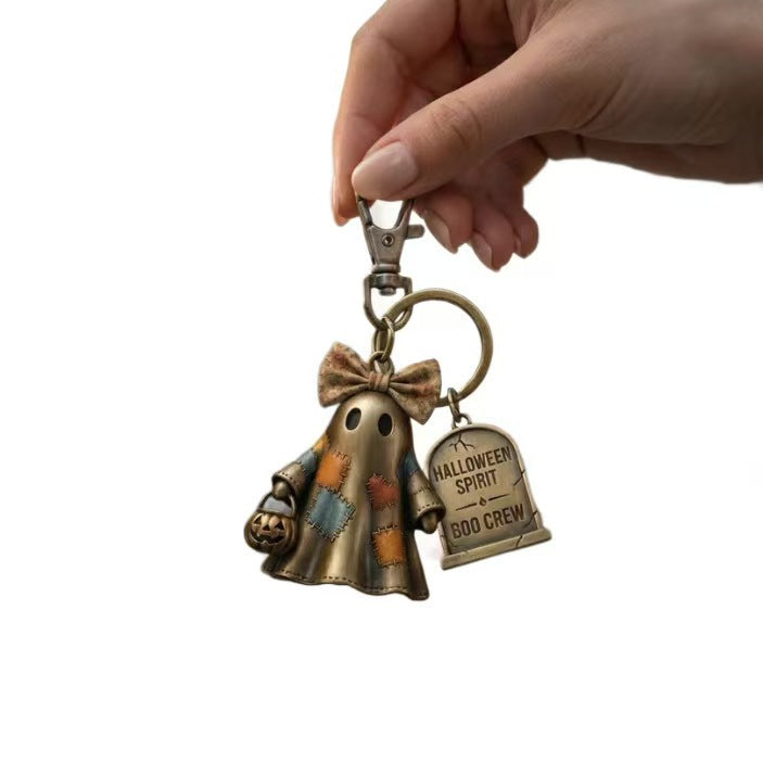Hand holding bronze Halloween ghost keychain with Boo Crew charm tag