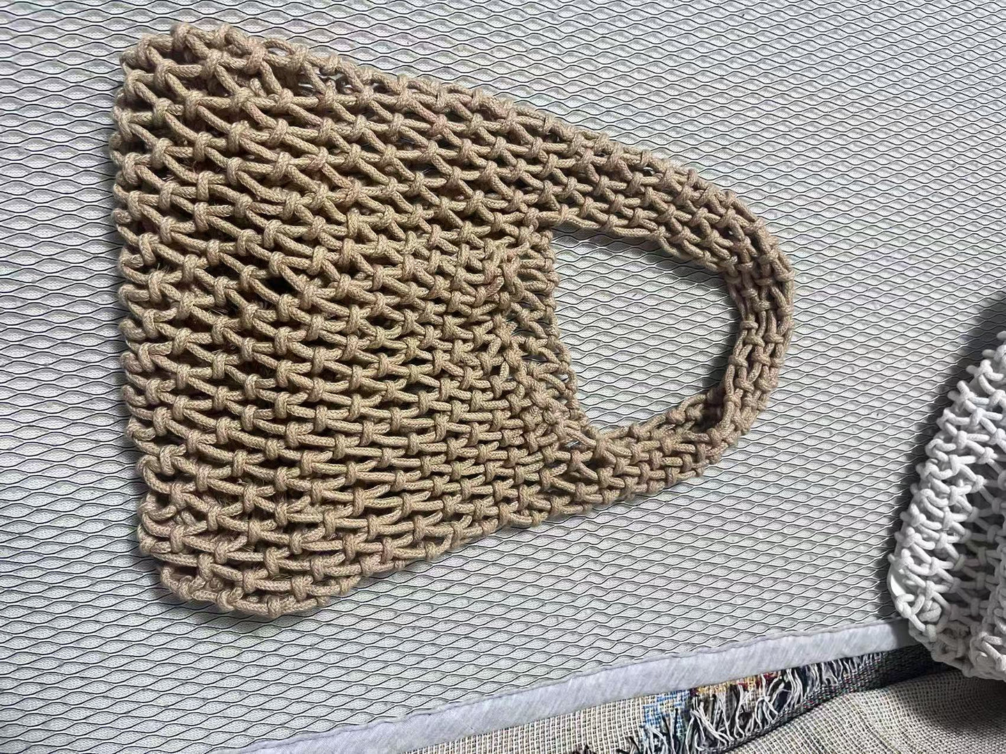 Beige rope woven bucket bag with top loop handle and hollow net weave