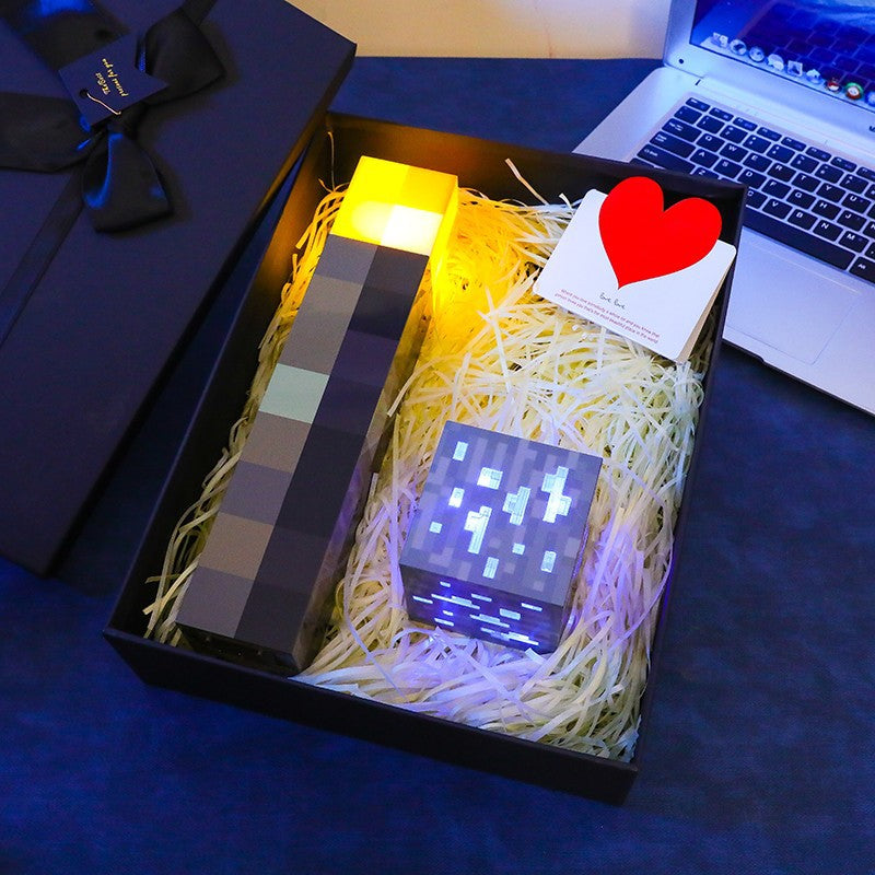Gift box with yellow pixel Minecraft-style torch night light and glowing light