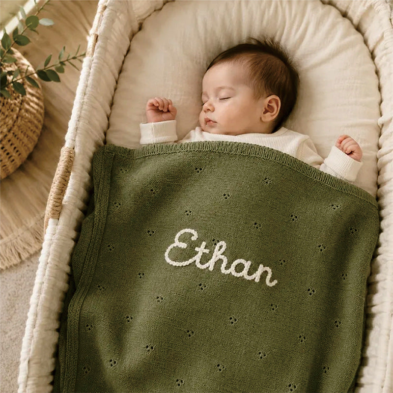 Green cotton baby blanket with small hollow floral embroidery and custom name "Ethan"