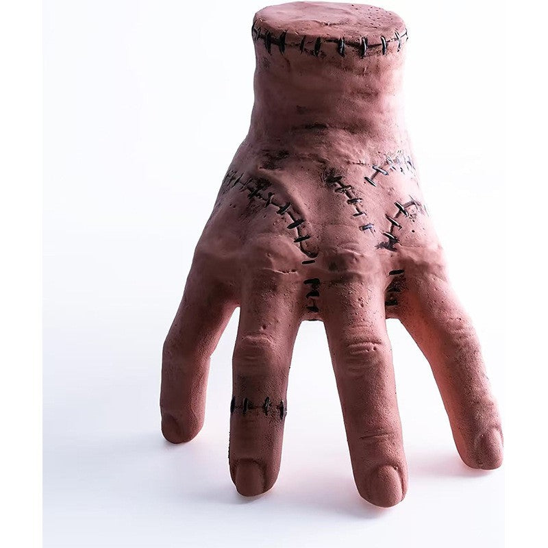 Halloween severed hand prop, pinkish flesh tone with stitched cuts across the palm.