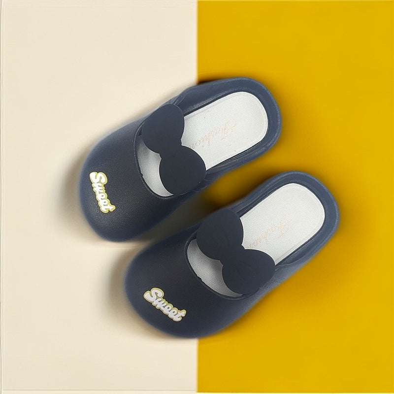 Girls' indoor slippers with bow, navy slip-ons and gold “Princess” script on side