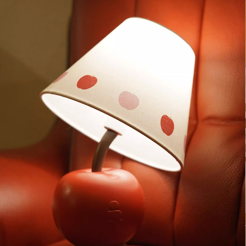 Apple-shaped bedside lamp with white heart-dotted shade and red apple base.