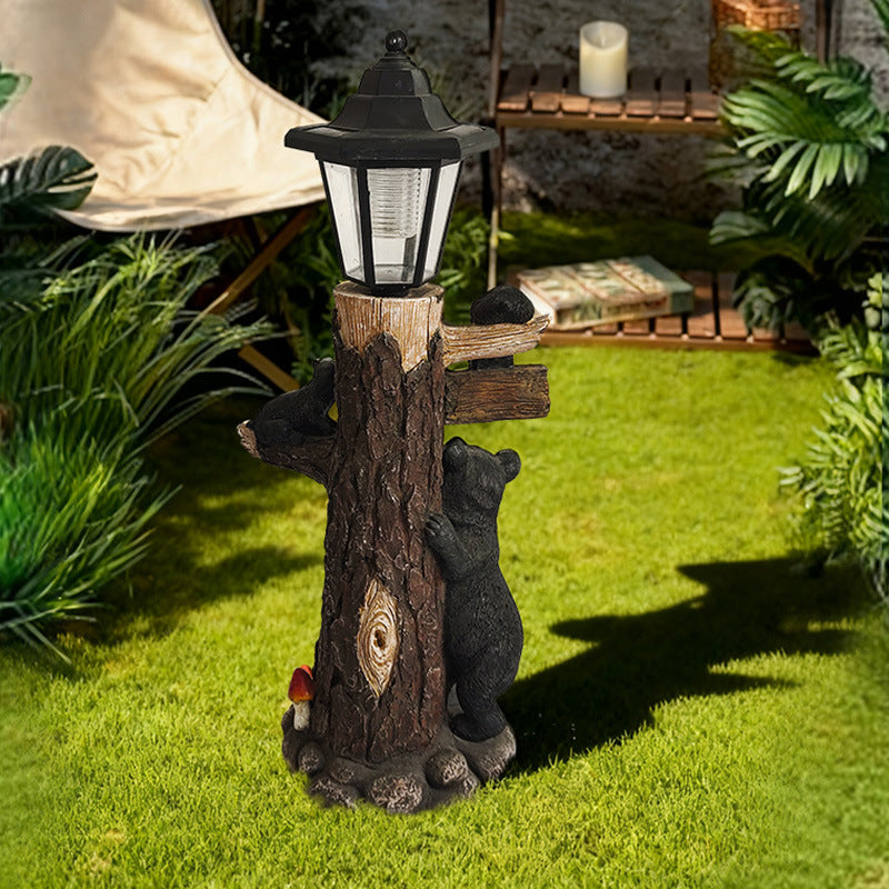 Solar garden light ornament showing lantern atop a wooden log with black koala figures