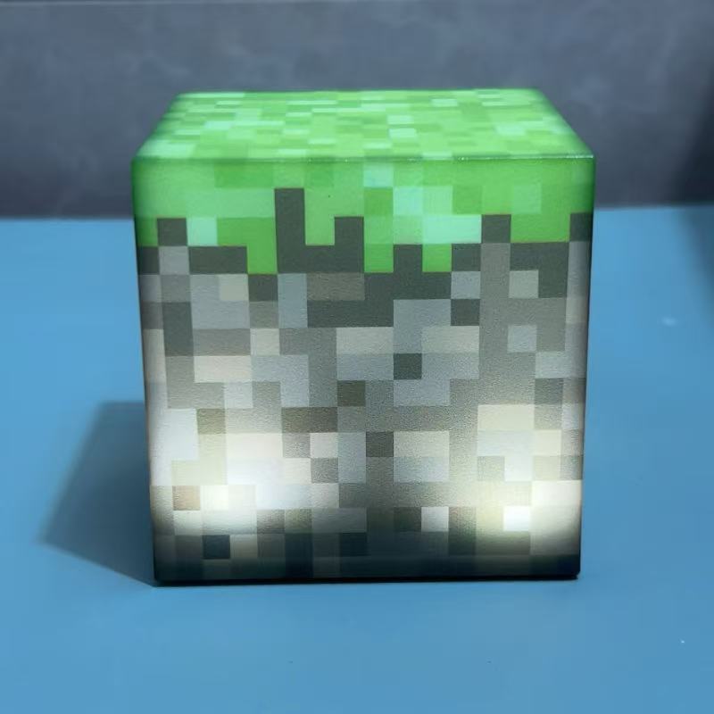 Green Minecraft-style cube night light with gray and white pixel camouflage pattern